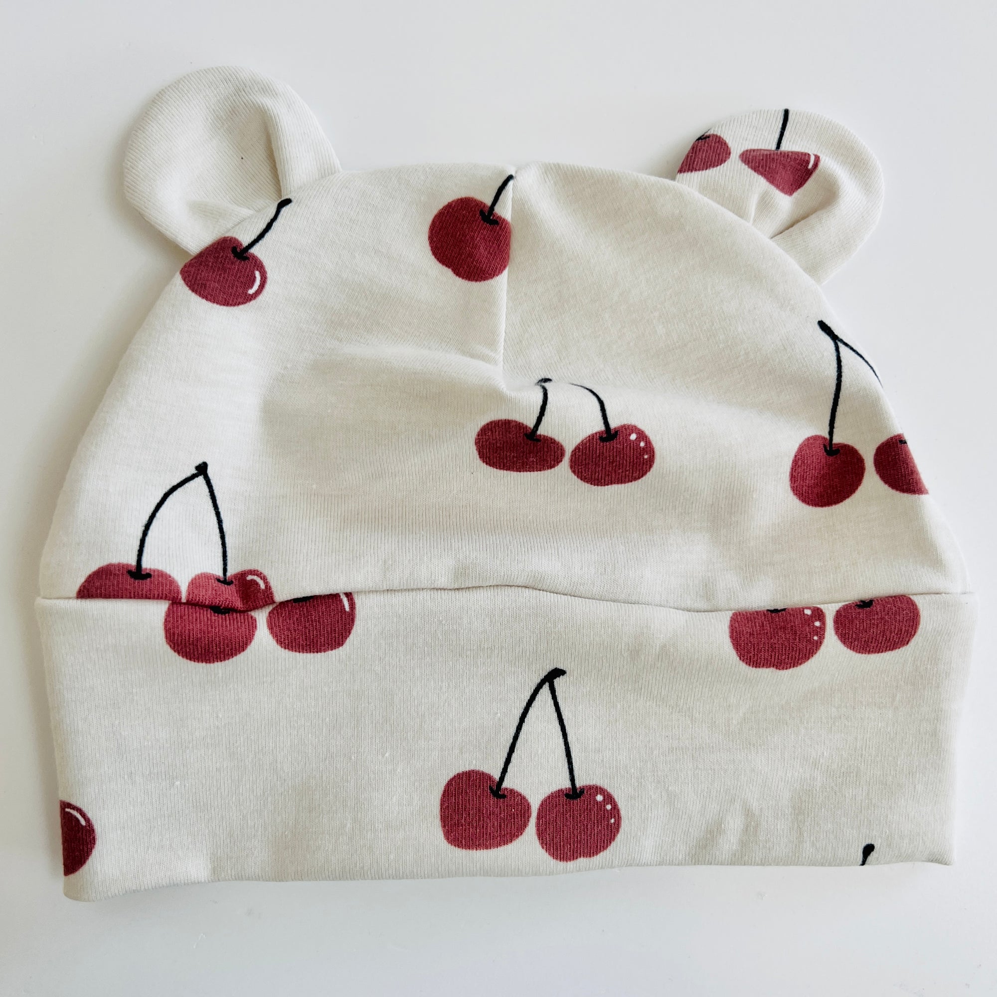 Eddie & Bee organic cotton Baby hat with ears  in Oat "Cherries" print.